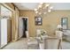Dining room with a glass table, comfortable seating, and chandelier, adjacent to a living area, neutral colors at 4612 35Th E Ave, Palmetto, FL 34221