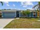 Single-story blue home with well-maintained landscaping, garage and palm trees at 4612 35Th E Ave, Palmetto, FL 34221