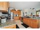 Bright kitchen featuring granite counters, wooden cabinets, and stainless steel appliances with tile floors at 4612 35Th E Ave, Palmetto, FL 34221