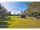 Sunny playground with slides, swings, and benches, surrounded by green grass and trees at 4612 35Th E Ave, Palmetto, FL 34221