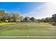 Well-maintained tennis court surrounded by lush trees and greenery under a clear blue sky at 4612 35Th E Ave, Palmetto, FL 34221
