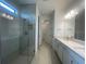 Bright bathroom with double vanity sinks, stone countertops, a glass-enclosed shower, and modern fixtures at 5014 Coastal Oak Ct, Lakewood Ranch, FL 34211