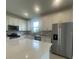 Modern kitchen with stainless steel appliances, white cabinetry, quartz countertops, and lots of natural light at 5014 Coastal Oak Ct, Lakewood Ranch, FL 34211
