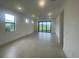 Open concept living room featuring neutral paint, tile floors, large windows, and sliding door access to outdoors at 5014 Coastal Oak Ct, Lakewood Ranch, FL 34211