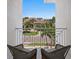 Relaxing balcony with seating and a view of the street, palm trees, and neighborhood homes at 5110 W Longfellow Ave, Tampa, FL 33629