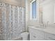 Bathroom with a white vanity, shower with grey shower curtain, and natural light at 5110 W Longfellow Ave, Tampa, FL 33629
