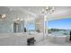 Luxurious bathroom featuring a large vanity area, marble floors, chandelier lighting, and water views at 5110 W Longfellow Ave, Tampa, FL 33629