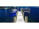 A private boat dock featuring lifts for a boat and jet ski, illuminated for nighttime enjoyment at 5110 W Longfellow Ave, Tampa, FL 33629