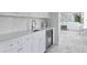Butler's pantry featuring a marble countertop, wine cooler, and intricate backsplash at 5110 W Longfellow Ave, Tampa, FL 33629