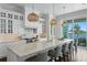 Well-appointed kitchen featuring a marble island, pendant lighting, and seamless connection to the outdoor dining area at 5110 W Longfellow Ave, Tampa, FL 33629