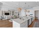 Open-concept kitchen and living area with white cabinetry, large island, and stainless steel appliances at 5110 W Longfellow Ave, Tampa, FL 33629