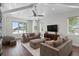Bright living room featuring hardwood floors, white coffered ceilings, and comfortable neutral furnishings at 5110 W Longfellow Ave, Tampa, FL 33629