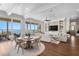 Open-concept living room featuring a dining area, waterfront views, hardwood floors, and custom built-ins at 5110 W Longfellow Ave, Tampa, FL 33629