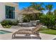 Relaxing outdoor lounge area with comfortable seating, an umbrella, and lush landscaping, perfect for leisure and entertaining at 5110 W Longfellow Ave, Tampa, FL 33629