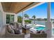 Covered outdoor seating area with comfortable furniture, fireplace, pool, and waterfront views at 5110 W Longfellow Ave, Tampa, FL 33629
