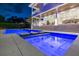 Luxury backyard featuring a swimming pool with a tanning ledge, and an illuminated outdoor living area at twilight at 5110 W Longfellow Ave, Tampa, FL 33629