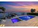 A luxurious pool and jacuzzi area at sunset, complete with a dock, inviting relaxation and entertainment at 5110 W Longfellow Ave, Tampa, FL 33629