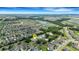 Expansive aerial view of a residential community featuring well-maintained homes, lush landscaping, and a serene lake at 5250 Brody Blvd, Wimauma, FL 33598