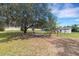 Spacious backyard with large trees and seating area, perfect for outdoor gatherings and relaxation at 5250 Brody Blvd, Wimauma, FL 33598