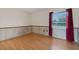 Bright bedroom with hardwood floors, a window with blinds, and wall paneling at 5250 Brody Blvd, Wimauma, FL 33598