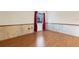 Bright bedroom featuring hardwood floors, a window with blinds and curtains, and wall paneling at 5250 Brody Blvd, Wimauma, FL 33598