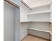 Walk-in closet featuring wooden rods and white shelving at 5250 Brody Blvd, Wimauma, FL 33598