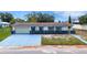 Charming single-story home featuring a blue and white exterior, attached garage, and a well-manicured front yard at 5250 Brody Blvd, Wimauma, FL 33598