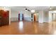 Spacious living room featuring hardwood floors, a ceiling fan, natural light and a wooden door at 5250 Brody Blvd, Wimauma, FL 33598