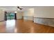 Open living room featuring hardwood floors, ceiling fan, sliding glass doors, and paneled walls at 5250 Brody Blvd, Wimauma, FL 33598