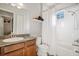 This bathroom features wood cabinets, granite countertops, a single sink, and a shower with tiled walls at 610 Winterside Dr, Apollo Beach, FL 33572