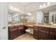 The primary bath boasts dual vanities with granite countertops, dark wood cabinets, and plenty of mirror space at 610 Winterside Dr, Apollo Beach, FL 33572