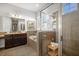 The well-lit bathroom features a glass-enclosed shower, a soaking tub, and wood cabinets with granite countertops at 610 Winterside Dr, Apollo Beach, FL 33572