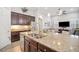Bright kitchen featuring a large island with seating, stainless steel appliances, and seamless flow to living area at 610 Winterside Dr, Apollo Beach, FL 33572