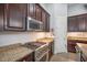 Modern kitchen showcasing stainless steel range and appliances with granite counters and dark cabinets at 610 Winterside Dr, Apollo Beach, FL 33572