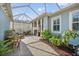 A relaxing outdoor patio area with potted plants, a patio table and chairs, and an aluminum roof for shade at 610 Winterside Dr, Apollo Beach, FL 33572