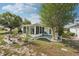 Picturesque backyard featuring a sunroom addition, mature trees, and charming garden accents at 708 Rutgers Pl, Sun City Center, FL 33573