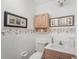 Charming half-bathroom featuring floral wallpaper, framed art, and a classic vanity at 708 Rutgers Pl, Sun City Center, FL 33573