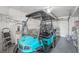 Well organized garage area features a bright blue golf cart at 708 Rutgers Pl, Sun City Center, FL 33573