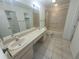Bright bathroom featuring a double sink vanity, tile flooring and a shower-tub combo at 7125 Silvermill Dr, Tampa, FL 33635