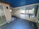 Enclosed patio with serene blue flooring, providing ample space and access to the outdoors at 7125 Silvermill Dr, Tampa, FL 33635
