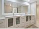 Bathroom vanity with double sinks, white cabinets, drawers and a large mirror at 739 1St Ct, Palm Harbor, FL 34684