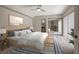 Bright bedroom with sliding glass doors, modern ceiling fan, and ensuite bathroom at 739 1St Ct, Palm Harbor, FL 34684
