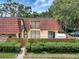 Charming two-story condo with a red tile roof and a well-maintained, enclosed front yard at 739 1St Ct, Palm Harbor, FL 34684