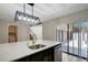 The kitchen island features a sink and dishwasher and opens to the sliding back door at 739 1St Ct, Palm Harbor, FL 34684
