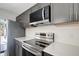 Updated kitchen showcasing stainless steel appliances and stylish gray cabinets at 739 1St Ct, Palm Harbor, FL 34684