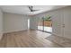 Bright living room with wood floors, fan, and sliding glass doors to a patio at 739 1St Ct, Palm Harbor, FL 34684