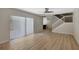 Open-concept living room with wood floors, staircase, and sliding doors for natural light at 739 1St Ct, Palm Harbor, FL 34684