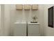 Functional laundry room with a washer, dryer, storage shelf, and tasteful decor at 7541 E 116Th St, Palmetto, FL 34221