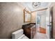 Elegant bathroom features a vanity with granite counters, a gold framed mirror, and decorative wallpaper at 7600 Bayshore Dr # 1201A, Treasure Island, FL 33706