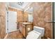 Bathroom with decorative wallpaper features a vanity with granite countertop and modern toilet at 7600 Bayshore Dr # 1201A, Treasure Island, FL 33706